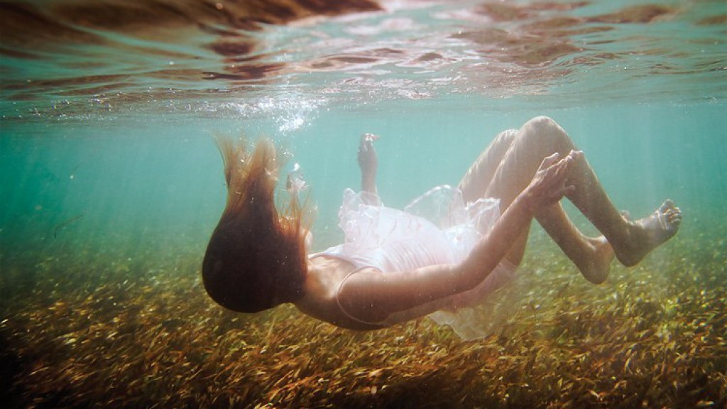 Стоя в воде подруга позирует голой на камеру фото